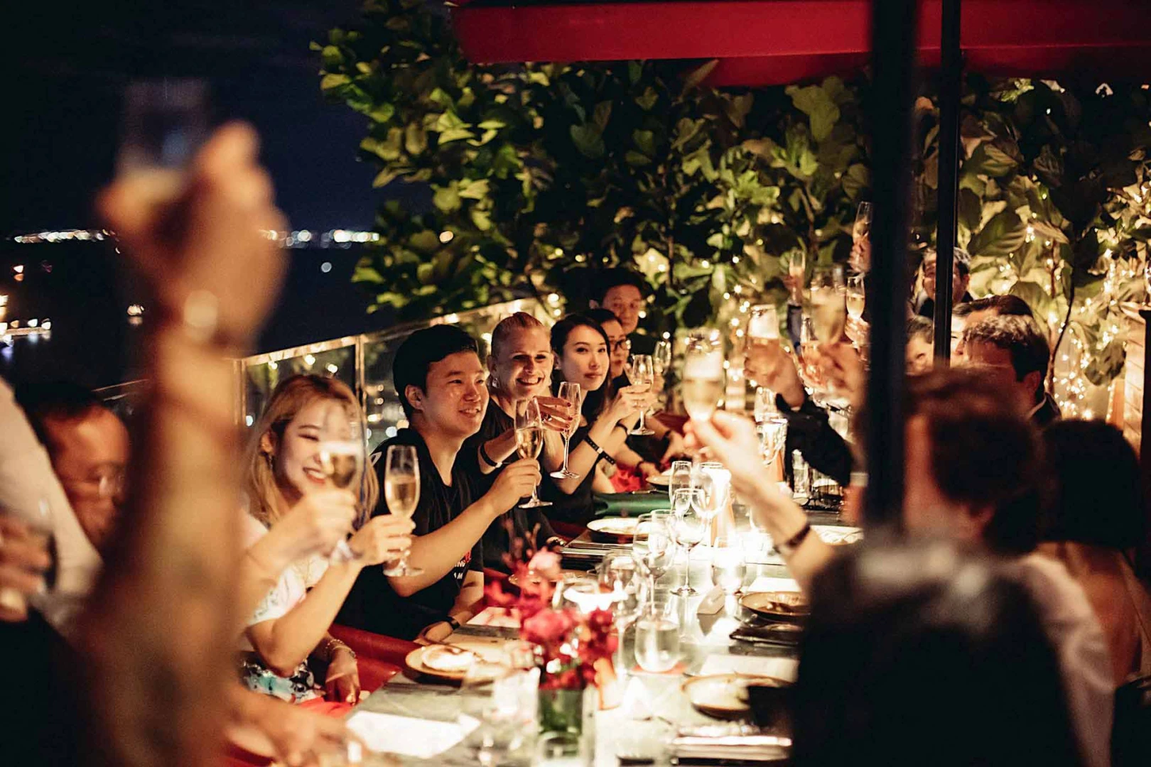 Guests toasting at CÉ LA VI Dubai rooftop dinner.
