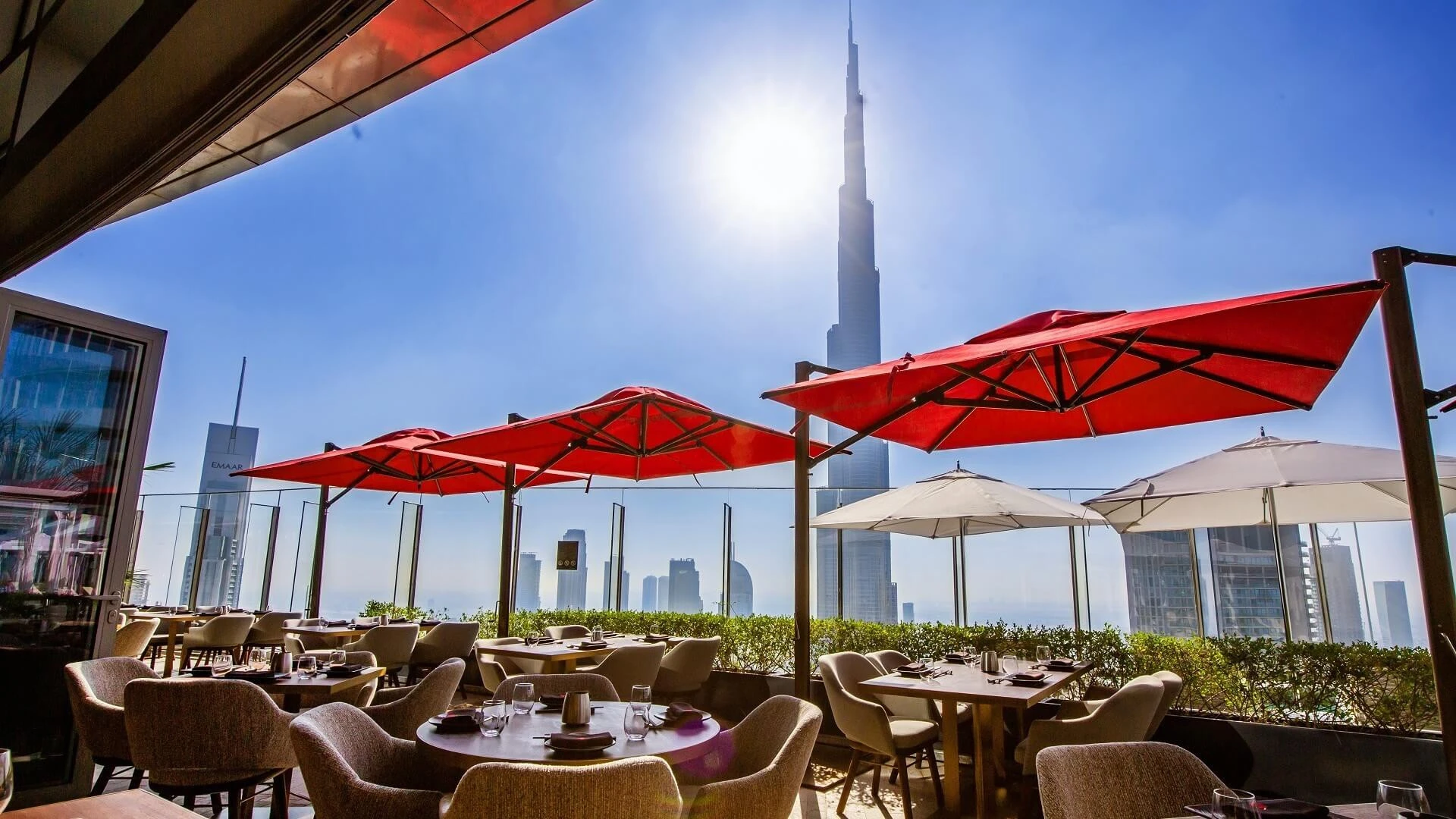 CÉ LA VI Dubai terrace with red umbrellas, Burj Khalifa view.