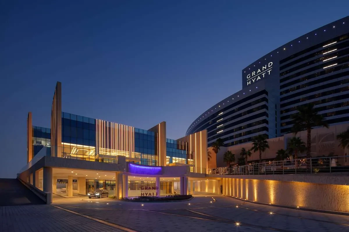 Grand Hyatt Dubai Convention Centre illuminated at night, modern architecture.