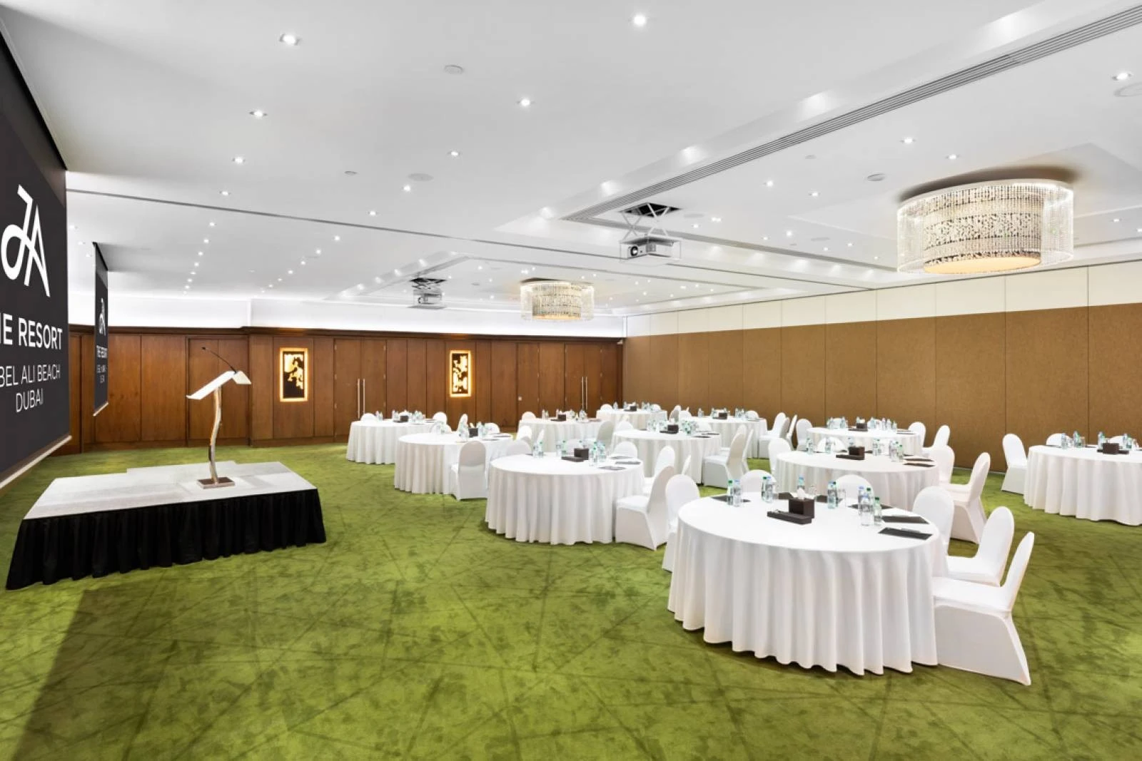 Elegant conference room at JA Beach Hotel, Dubai with round tables.