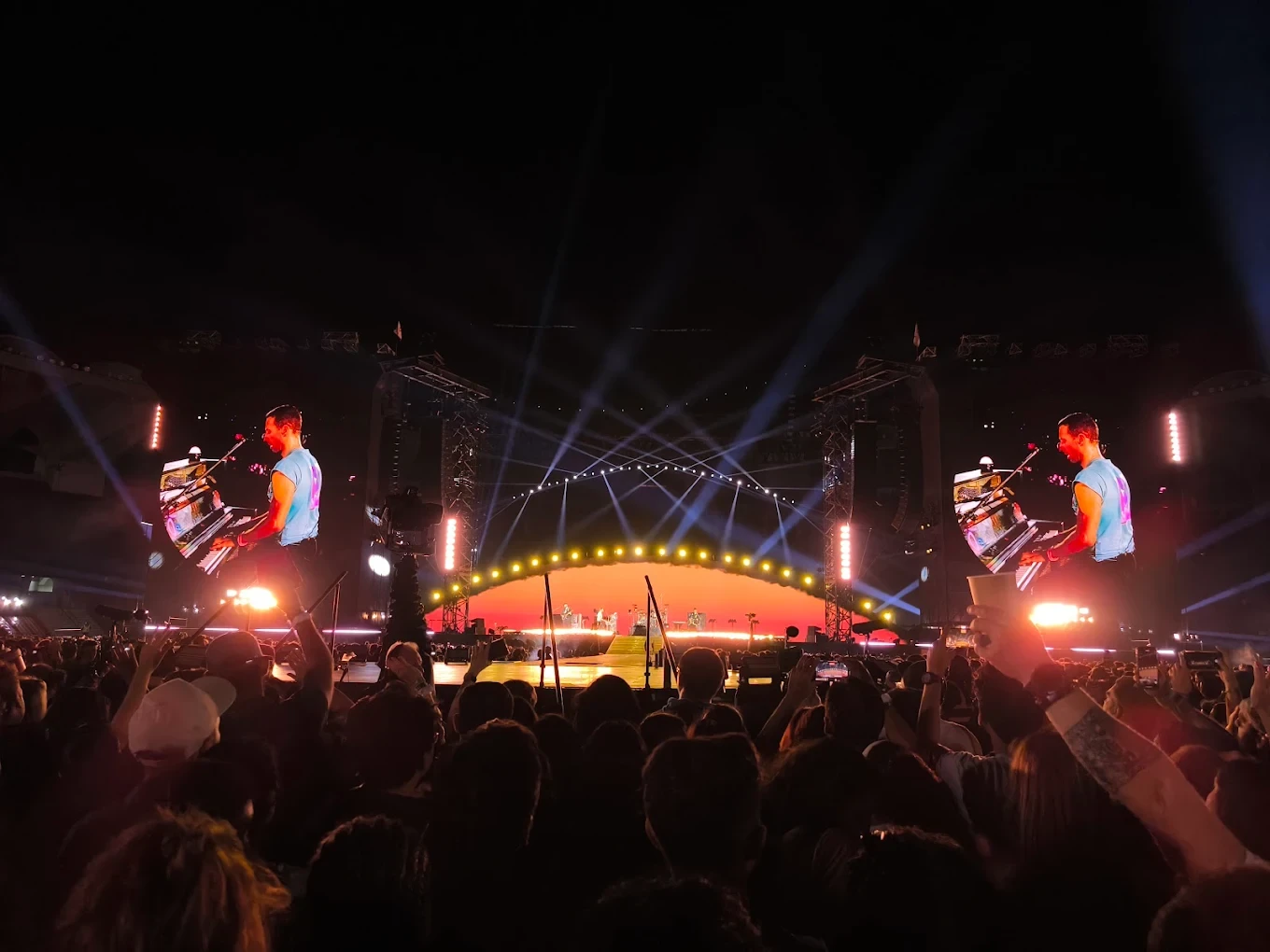 Concert at Zayed Sports City, Abu Dhabi, with vibrant stage lights.